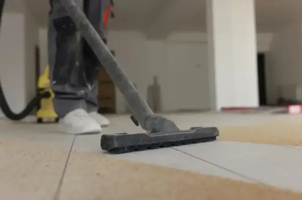 Nettoyage de carrelage après chantier : un aspirateur passe sur le sol pour enlever les débris.