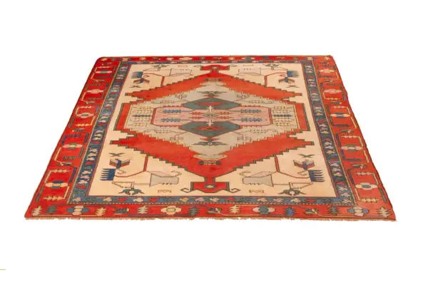 A rectangular Turkish rug with a cream-colored field, red geometric patterns, and a blue and red border.