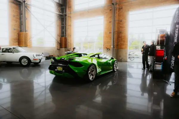 Une Lamborghini verte et une Porsche blanche dans un showroom. Le rachat LOA par concessionnaire est une option pour acquérir ces merveilles.