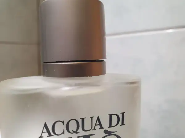 Szklana butelka z napisem ACQUA DI GIO 100ml, z metalową nakrętką.