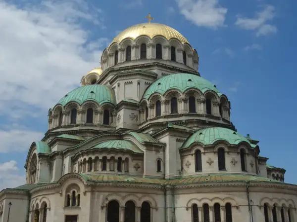 Katedra Aleksandra Newskiego w Sofii, z jej złotą kopułą i zielonymi dachami, góruje nad błękitnym niebem.