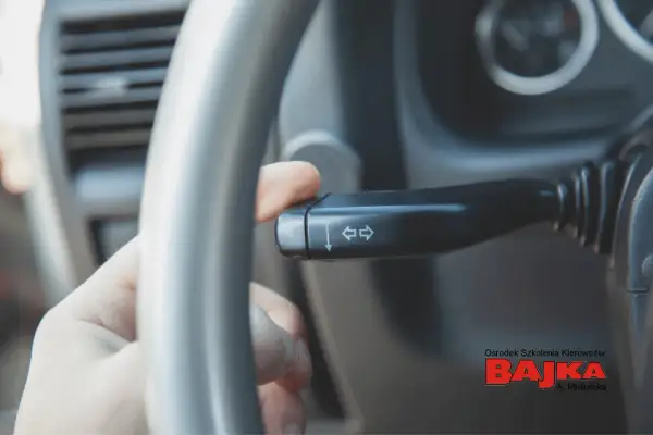 Palec naciska dźwignię kierunkowskazu, sygnalizując zamiar skrętu. Pamiętaj, kiedy włączać kierunkowskaz!