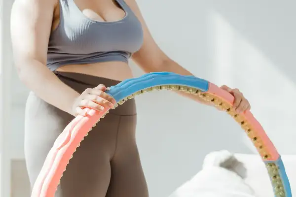 Frau zerlegt einen Hula Hoop Reifen in bunte Segmente.