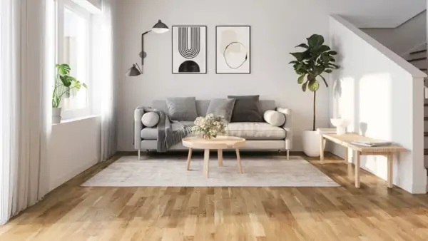Ljust golv inspiration i ett modernt vardagsrum med grå soffa, rund soffbord och en stor grön växt.