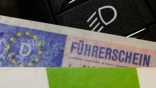 Führerschein mit EU-Sternen und "D" für Deutschland, daneben ein Lichtschalter. Bereit für die Fahrt nach § 24 StVG.