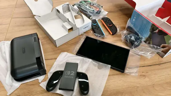 Zawartość pudełka Nintendo Switch: konsola, dwa kontrolery Joy-Con (niebieski i pomarańczowy), stacja dokująca i kable.
