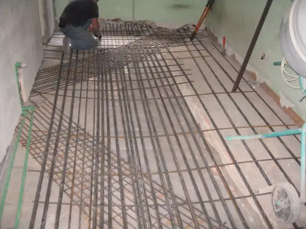 Operaio posa armatura per la caldana solaio. Rete metallica pronta per il getto di calcestruzzo.