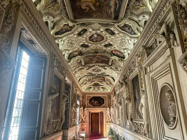 Corridoio decorato con affreschi e sculture nel **Palazzo Spada Roma**. Soffitto a volta con scene mitologiche e figure allegoriche.
