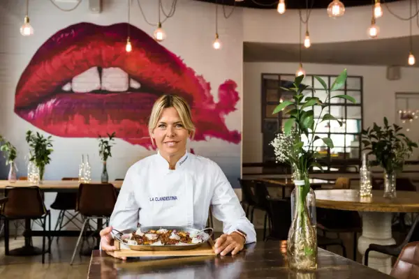 Chef sonríe con un plato de comida en "La Clandestina", uno de los mejores restaurantes Zaragoza centro.