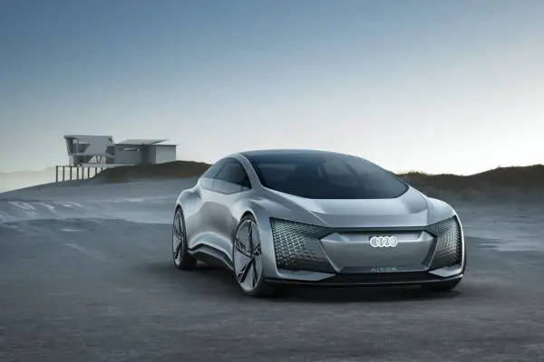 Srebrny Audi A9 AI:CON na tle nowoczesnego domu na wydmach. Futurystyczny design, podświetlany grill.