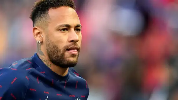 Neymar w charakterystycznych fryzurach, z kolczykami i tatuażami, w granatowej bluzie z napisem "PARIS".