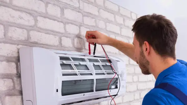 Technik sprawdza klimatyzację. Dowiedz się, ile kosztuje serwis klimatyzacji, aby zapewnić jej sprawność.