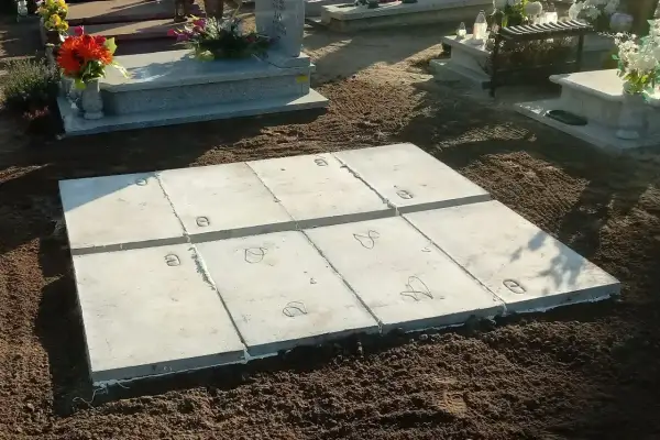 Rozpoczęcie prac nad wykonaniem piwniczki na cmentarzu. Betonowe płyty ułożone na ziemi, gotowe do dalszych etapów budowy.