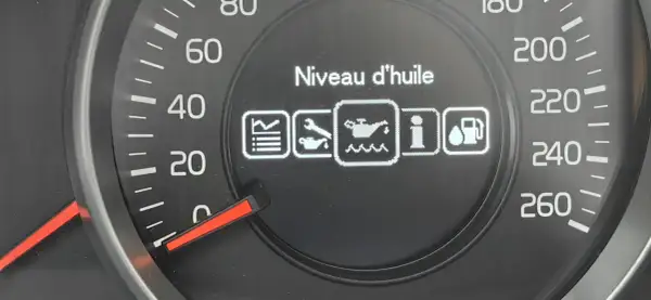 Na desce rozdzielczej Volvo V40 wyświetla się komunikat "Niveau d'huile" (poziom oleju) z ikoną wskazującą, że poziom oleju jest niedostępny.