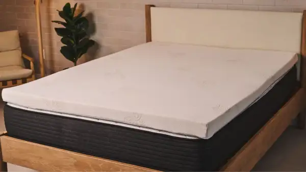 A new mattress with a white topper. This image helps answer: should I put a mattress topper on a new mattress?