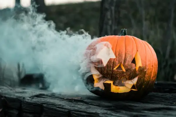 Dym wydobywa się z wyciętej dyni, która wygląda jakby czekała na Halloween.