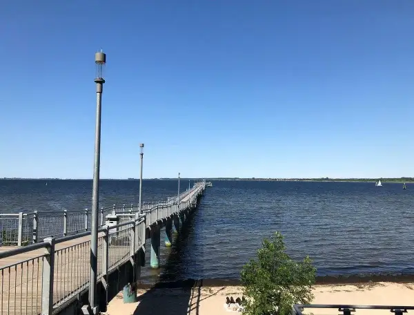 Langer Steg am Wismar Strand, der ins tiefblaue Wasser führt. Ein perfekter Ort für einen Spaziergang.