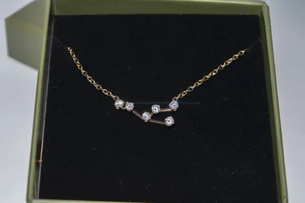 Colgante Tauro con circonitas brillantes en una caja verde.