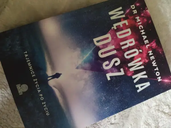 Okładka książki "Wędrówka dusz" Dr Michaela Newtona. Sylwetka człowieka na tle kosmicznego krajobrazu.