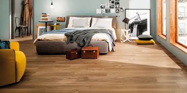 Camera da letto moderna con pavimento effetto legno, che ricorda i materiali lapidei per la sua resistenza e bellezza.