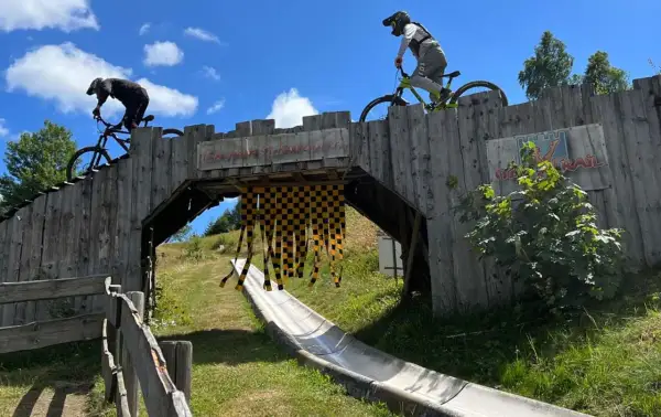Två cyklister på en träbro i en bikepark i Tyskland. En perfekt plats för en äventyrlig semester.