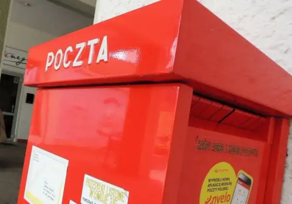 Czerwona skrzynka pocztowa z napisem "POCZTA". Warto pamiętać o poprawnym wpisaniu kodu pocztowego Toruń, aby list trafił do adresata.