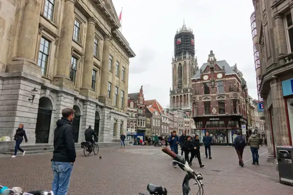 Menschen spazieren durch die Kopfsteinpflasterstraßen der utrecht altstadt, vorbei an historischen Gebäuden und dem Domturm.
