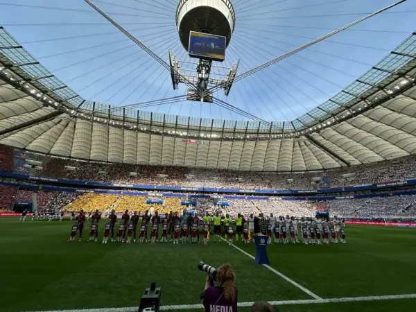 Piłkarze i dzieci stoją na murawie stadionu przed meczem Pucharu Polski.
