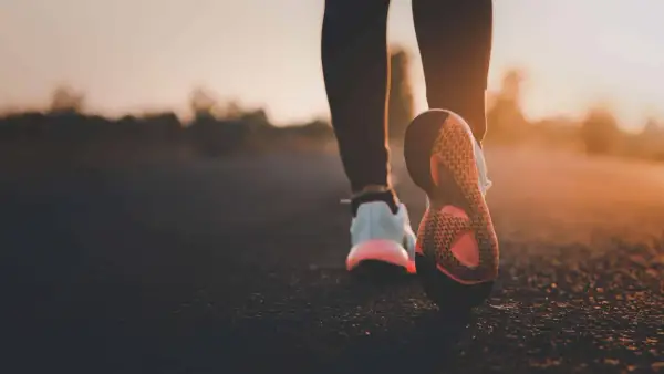 Scarpe da corsa al tramonto, un passo dopo l'altro per bruciare calorie camminata.