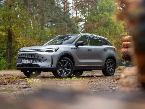 Srebrny SUV w lesie, gotowy na przygodę. Wiele osób chwali go w baic 7 opiniach za styl i osiągi.
