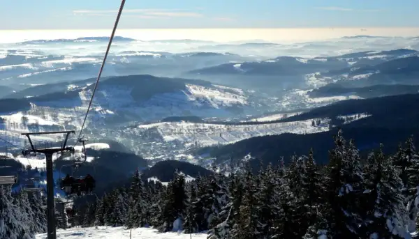 Blick vom Sessellift im Rokytnice Skigebiet auf verschneite Berge und Täler.