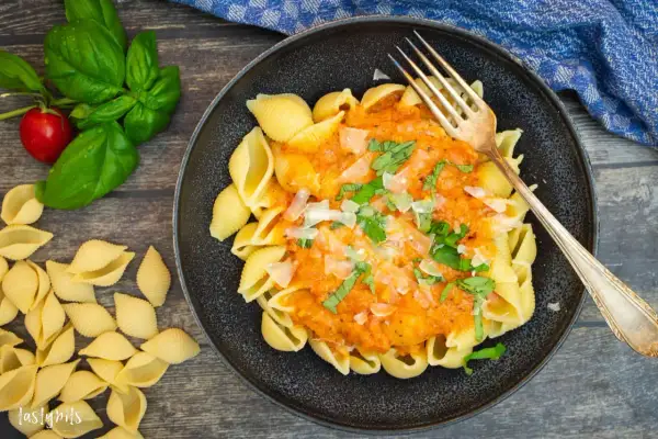 Schalen-Nudeln mit cremiger Tomaten-Sahne-Sauce, garniert mit Basilikum und Parmesan. Ein Genuss!