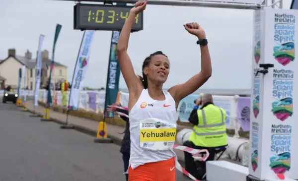 Victoire de Yehualaw, record semi marathon femme, franchissant la ligne d'arrivée avec les bras levés.