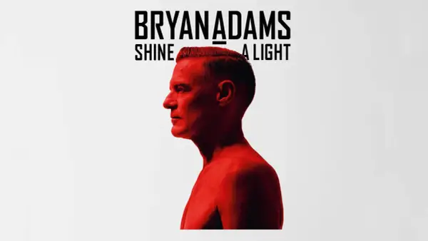 Bryan Adams Shine A Light. Okładka albumu z wizerunkiem artysty w czerwonym świetle.