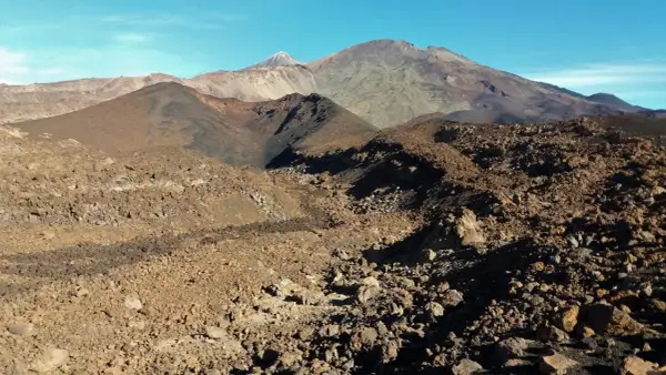 Paisaje volcánico árido visto desde el mirador de Samara, con montañas y conos de ceniza bajo un cielo azul.