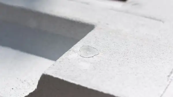 Kropla wody na porowatej powierzchni bloczków z perlitu. Materiał budowlany w zbliżeniu.