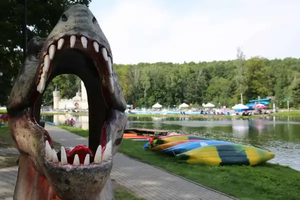 Przez paszczę dinozaura widać zamek i basen. To jedne z magicznych miejsc opolskich, gdzie czeka wodna zabawa i kajaki.