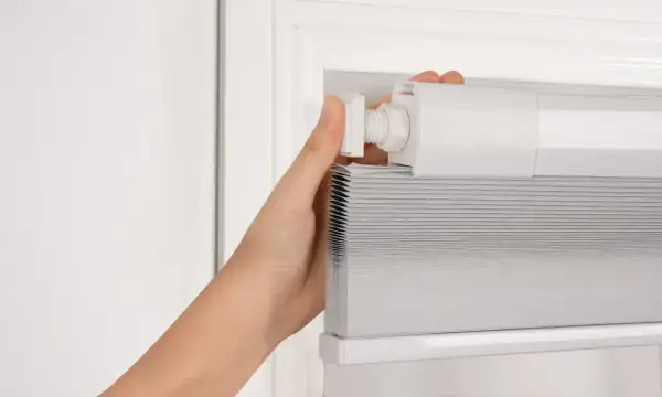 Instalación de un estor enrollable, una de las soluciones para ventanas sin persianas.