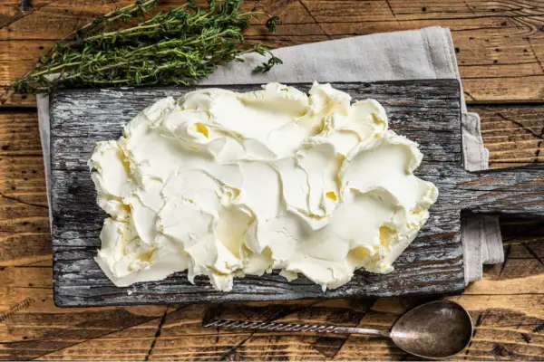 Kremowe mascarpone na desce. Zastanawiasz się, czy mascarpone można mrozić? Ten ser jest idealny do deserów, ale mrożenie może zmienić jego konsystencję.