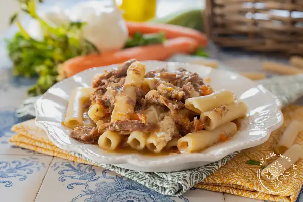 Piatto di ziti alla genovese con ragù di carne sfilacciata e verdure. Un classico della cucina napoletana.