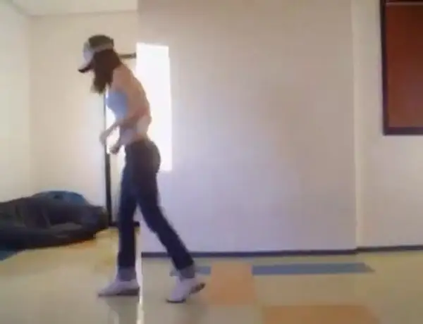 Ragazza con cappellino e jeans che si muove a ritmo, mostrando come si balla la techno con passi energici.