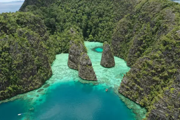 Atemberaubende Karstinseln mit üppiger Vegetation umgeben türkisfarbenes Wasser. Perfekt für die raja ampat beste reisezeit.