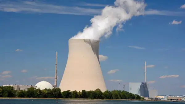 Chłodnia kominowa i budynki elektrowni atomowych w Niemczech na tle błękitnego nieba.