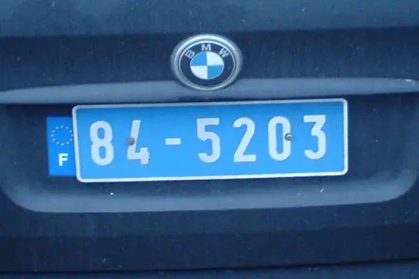 Plaque immatriculation bleue avec le sigle "F" et des étoiles européennes, typique de la France. Le numéro est 84-5203.