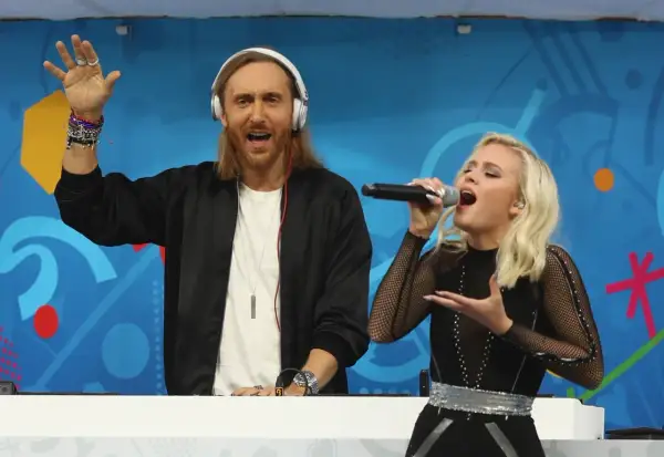 David Guetta Polska: DJ z mikrofonem i wokalistka na scenie, bawią publiczność.