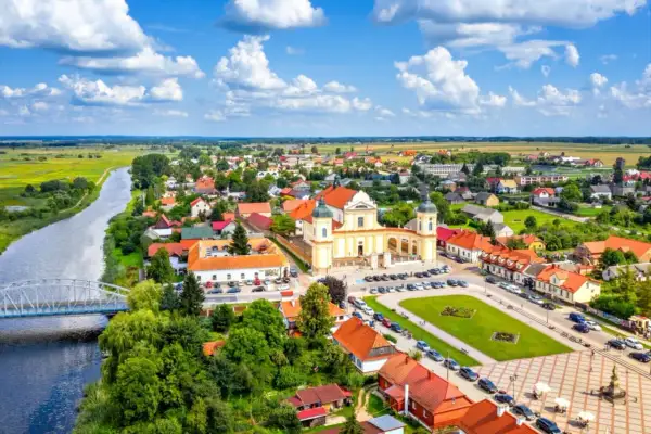 Malowniczy widok na Tykocin z rzeką, mostem i barokową bazyliką. Odkryj **Tykocin atrakcje** i poczuj klimat tego miejsca.