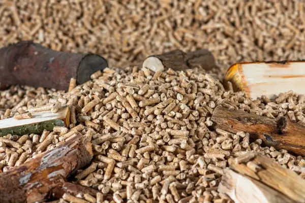Góra pelletu z kawałkami drewna. Szukasz sposobu, jak tanio kupić pellet? Oto rozwiązanie!