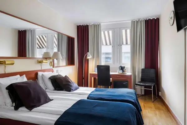 Dubbelrum med två sängar, mörkläggningsgardiner, skrivbord och spegel. Ett bekvämt och funktionellt rum på detta **sure hotel**.