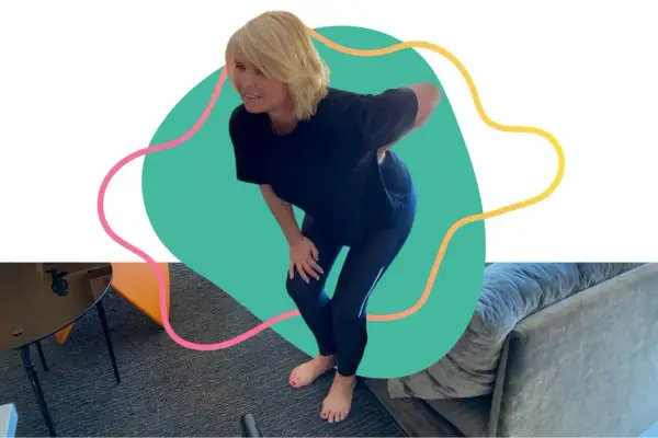 Femme se tenant le bas du dos, le visage crispé par la douleur. La question "peut on marcher avec une sciatique ?" est soulevée par cette posture.
