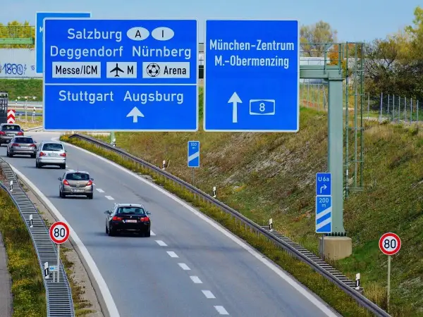 Autostrady w Niemczech: znaki kierunkowe do Salzburga, Norymbergi, Stuttgartu, Augsburgu i centrum Monachium. Ruch samochodowy.